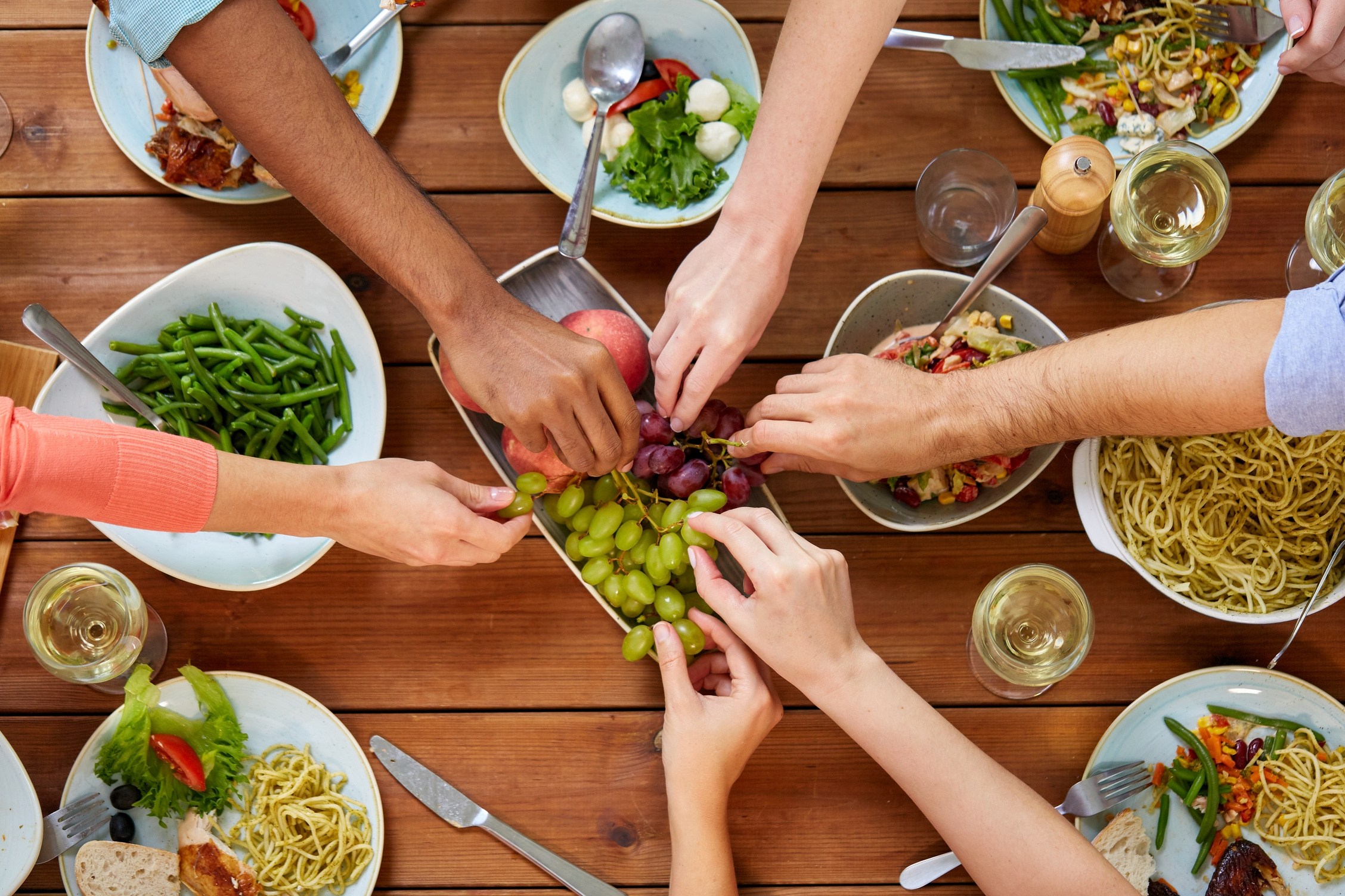 Group of People Eating at Table with Food